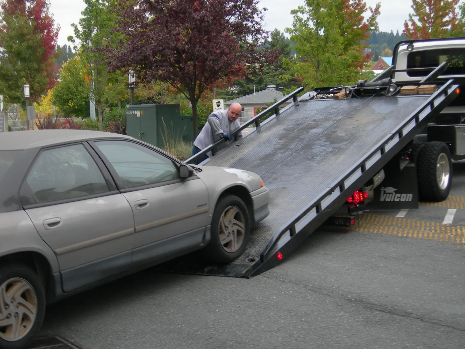 Car being loaded onto a flatbed tow truck